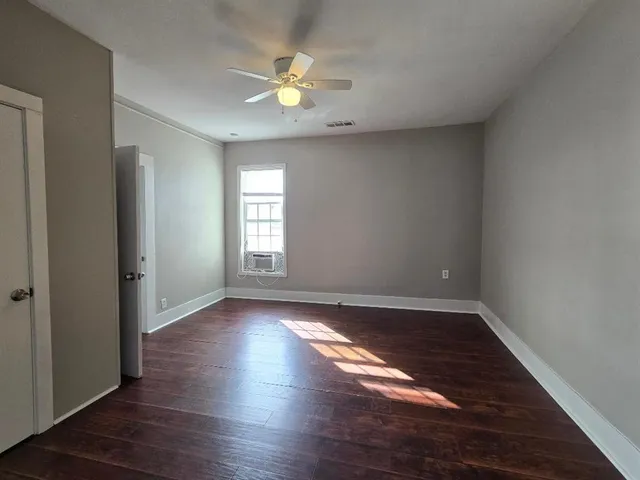 an empty room with wooden floor and window