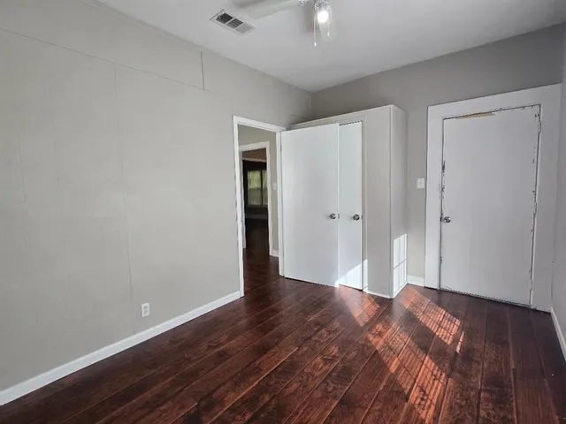a view of an empty room with wooden floor
