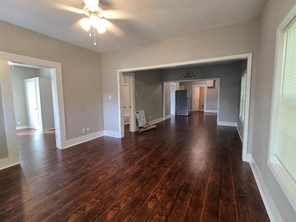114 South 20th Street Corsicana, TX 75110 - Photo 3 of 15 an empty room with wooden floor and ceiling fan