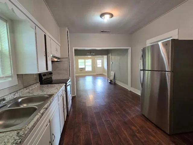 a kitchen with a refrigerator sink and wooden floor