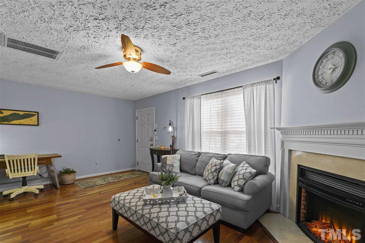 7050 Jeffreys Creek Lane Raleigh, NC 27616 - Photo 4 of 23 a living room with furniture a fireplace and a large window