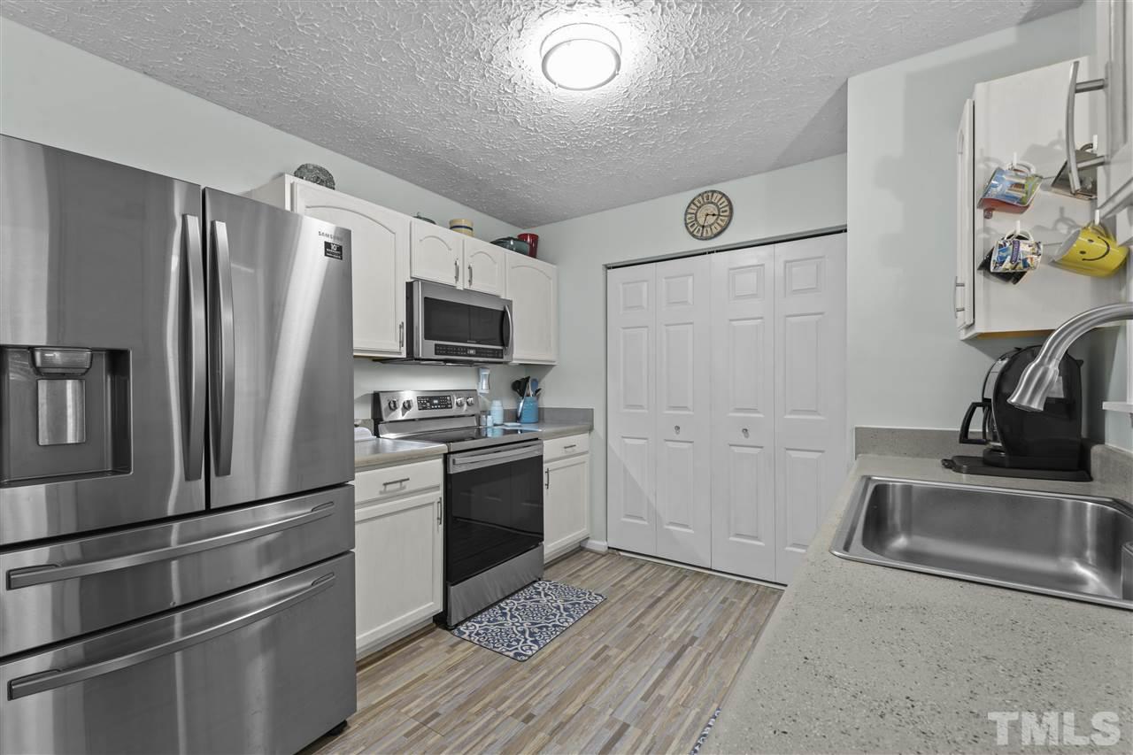 7050 Jeffreys Creek Lane Raleigh, NC 27616 - Photo 6 of 23 a kitchen with a refrigerator stove and wooden floor