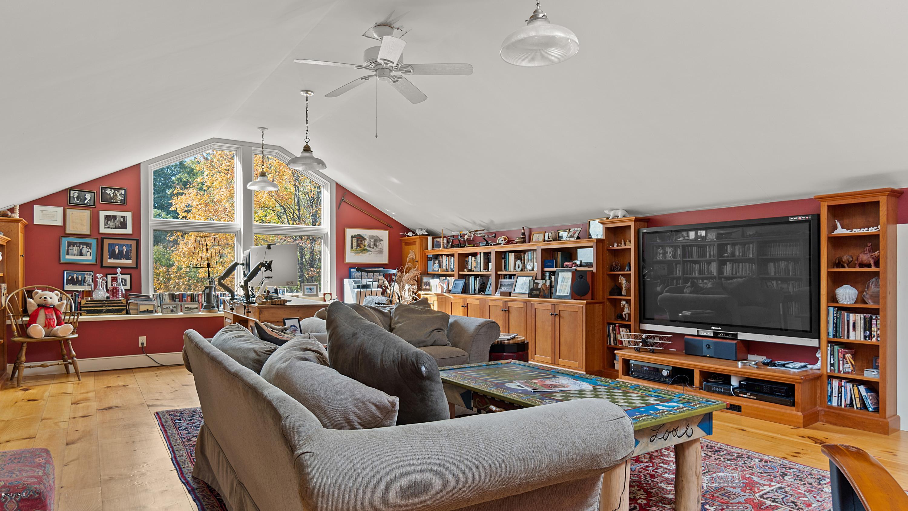 1204 Ashley Falls Road Sheffield, MA 01257 - Photo 31 of 55 a living room with furniture a flat screen tv and a floor to ceiling window
