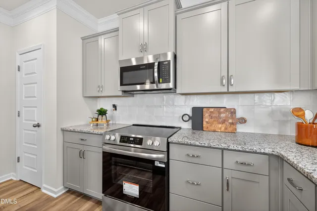 a kitchen with granite countertop white cabinets stainless steel appliances and sink