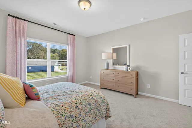 a spacious bedroom with a bed a window and a chandelier
