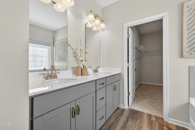 a en suite bathroom with a granite countertop tub double vanity and a shower