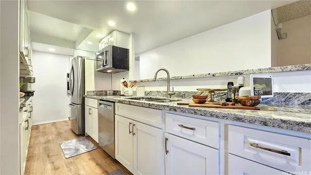 a kitchen with stainless steel appliances granite countertop a sink and a refrigerator