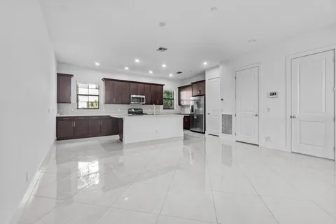 a view of a kitchen with refrigerator and windows