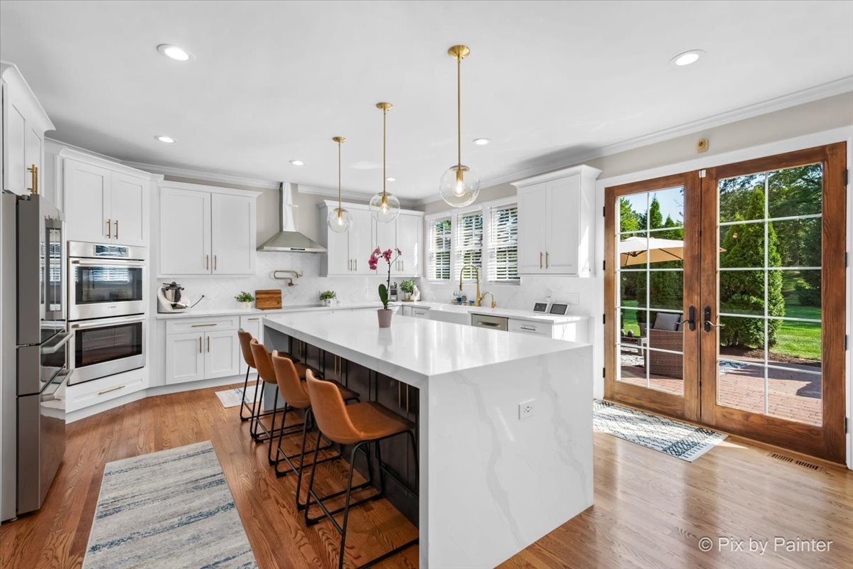 36W575 Bristol Road St. Charles, IL 60175 - Photo 13 of 58 a kitchen with stainless steel appliances kitchen island granite countertop a stove top oven a sink dishwasher a dining table and chairs with wooden floor