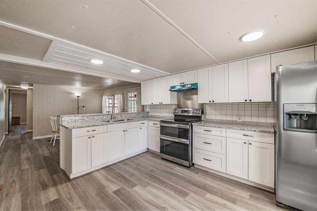 9739 Ray Street Hudson, FL 34669 - Photo 15 of 36 a kitchen with a sink stove cabinets and refrigerator