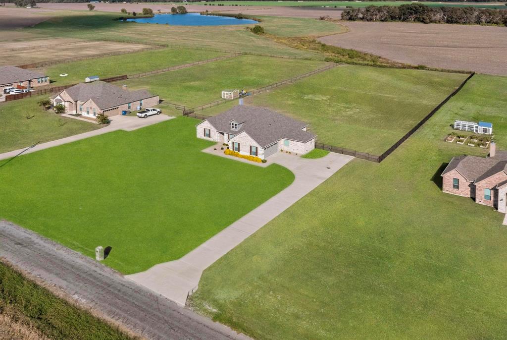 634 Gant Road Sherman, TX 75090 - Photo 5 of 40 Single-story residence featuring a gray shingle roof, light-colored brick exterior, and an expansive green lawn