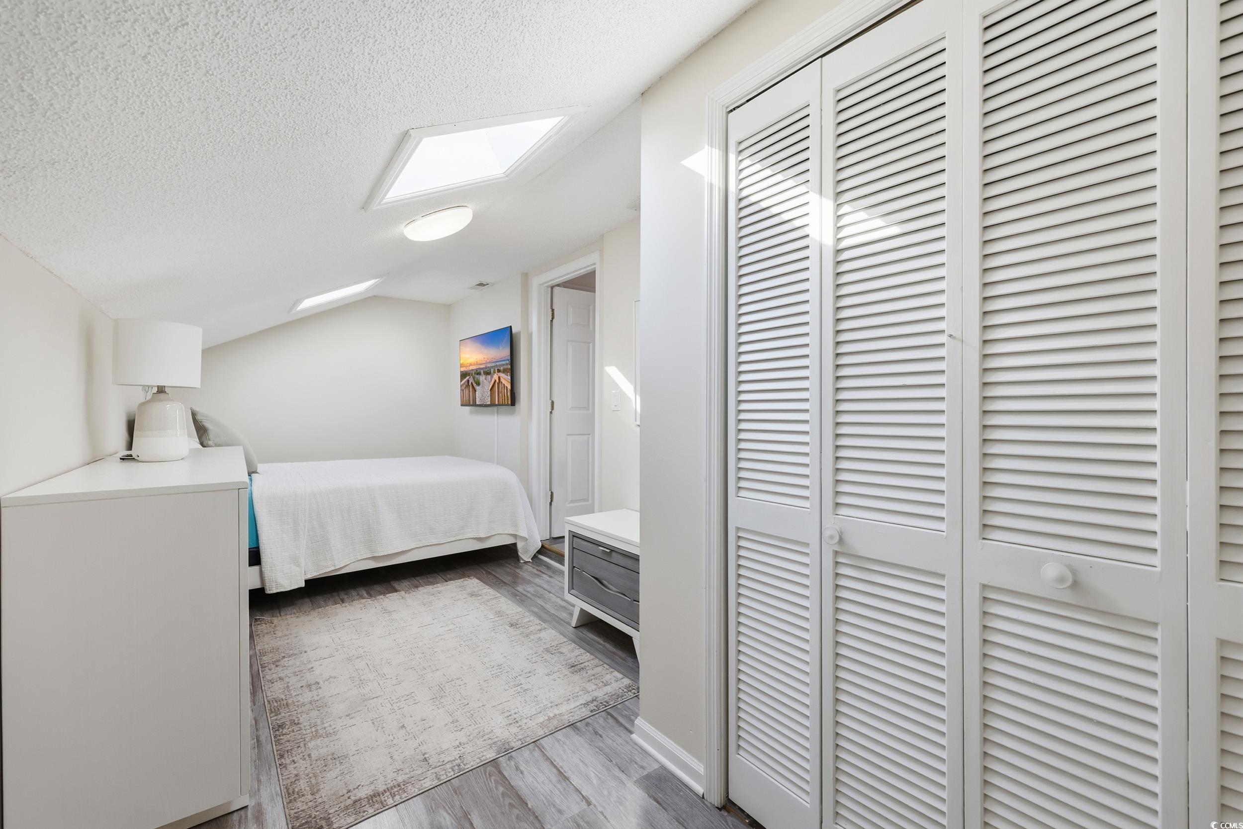 202 Double Eagle Drive, Unit C3 Surfside Beach, SC 29575 - Photo 14 of 20 Bedroom with a textured ceiling, dark wood-style flooring, and a closet