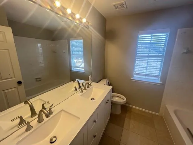 a spacious bathroom with a granite countertop sink a toilet and shower
