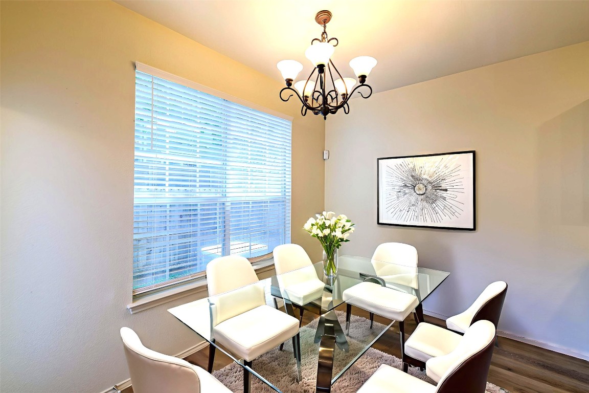 2632 Century Park Boulevard, Unit 18 Austin, TX 78727 - Photo 11 of 32 Dining area featuring wood finished floors and a chandelier