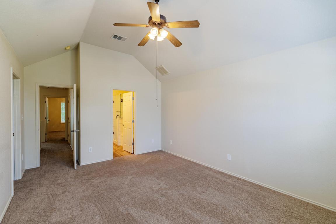 2632 Century Park Boulevard, Unit 18 Austin, TX 78727 - Photo 15 of 32 Unfurnished bedroom with high vaulted ceiling, light carpet, ceiling fan, and ensuite bathroom