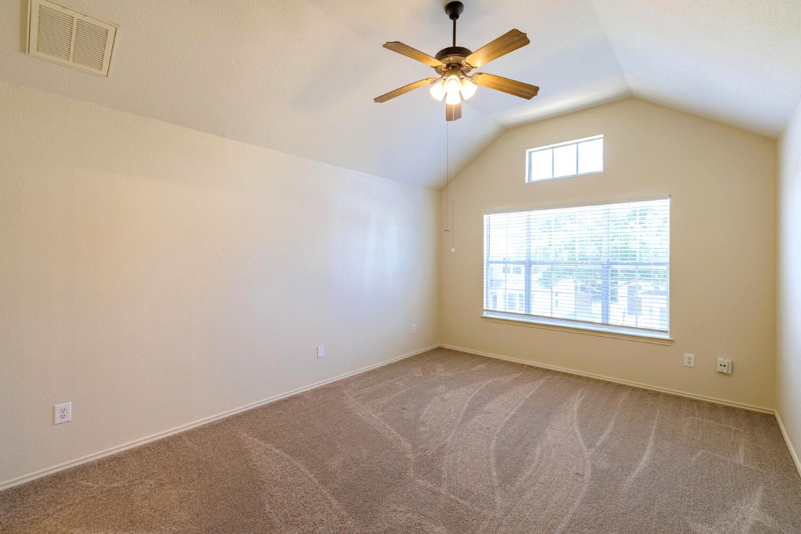 2632 Century Park Boulevard, Unit 18 Austin, TX 78727 - Photo 16 of 32 Carpeted spare room featuring lofted ceiling and a ceiling fan