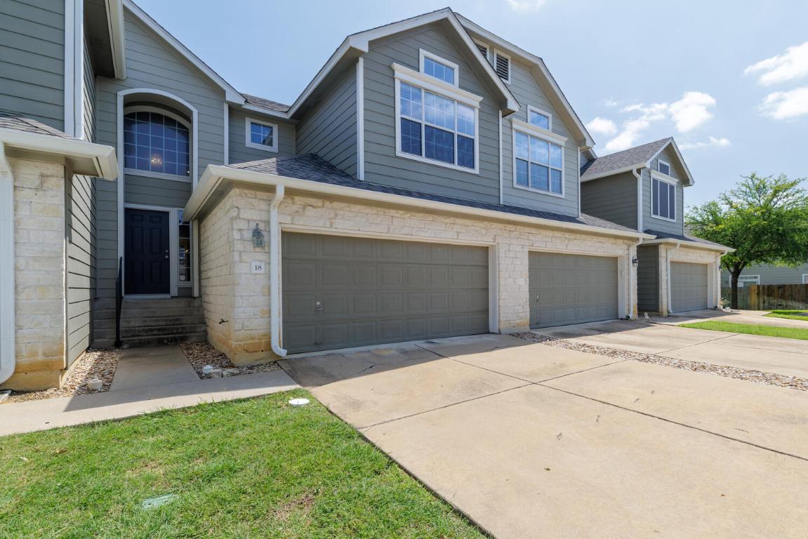 2632 Century Park Boulevard, Unit 18 Austin, TX 78727 - Photo 2 of 32 View of front of home featuring concrete driveway, a shingled roof, a garage, and stone siding
