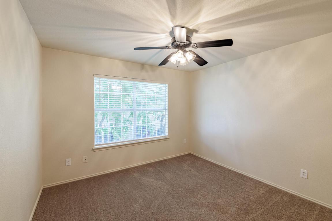 2632 Century Park Boulevard, Unit 18 Austin, TX 78727 - Photo 22 of 32 Empty room with dark carpet and baseboards