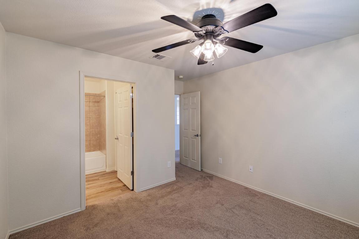 2632 Century Park Boulevard, Unit 18 Austin, TX 78727 - Photo 23 of 32 Unfurnished bedroom featuring light carpet, a ceiling fan, and connected bathroom