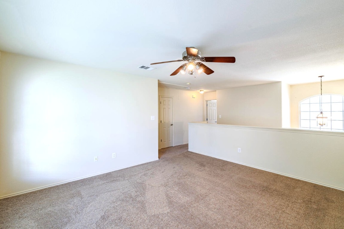 2632 Century Park Boulevard, Unit 18 Austin, TX 78727 - Photo 27 of 32 Empty room with carpet, a ceiling fan, and a chandelier