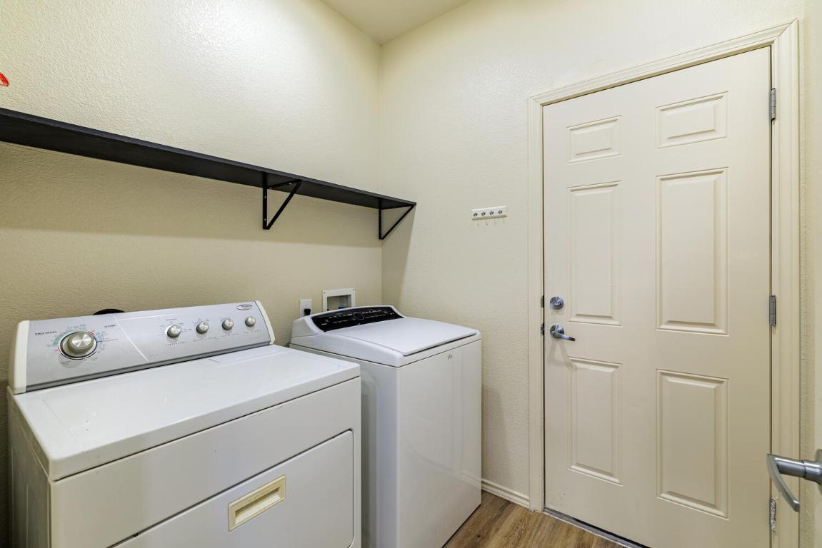 2632 Century Park Boulevard, Unit 18 Austin, TX 78727 - Photo 28 of 32 Laundry room featuring light wood-style flooring, washing machine and dryer, and a textured wall