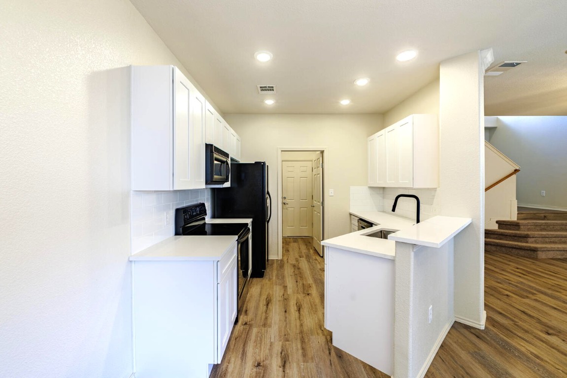 2632 Century Park Boulevard, Unit 18 Austin, TX 78727 - Photo 4 of 32 Kitchen with decorative backsplash, white cabinets, electric stove, and recessed lighting