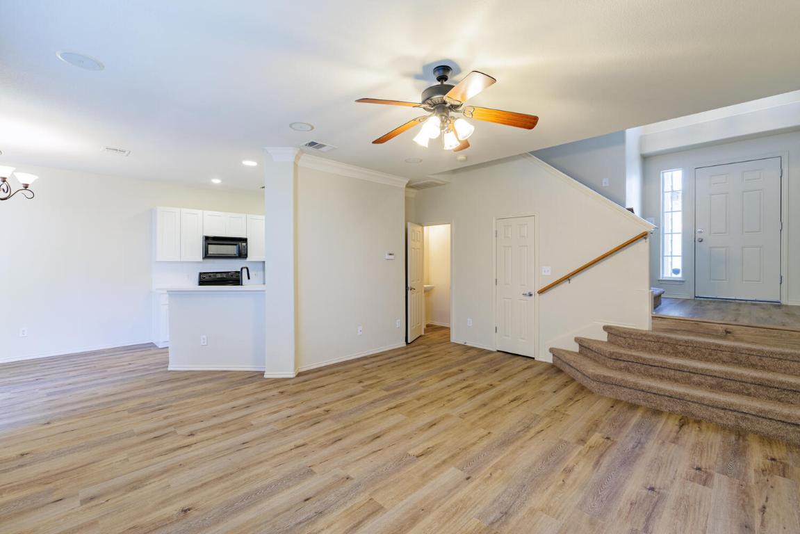 2632 Century Park Boulevard, Unit 18 Austin, TX 78727 - Photo 7 of 32 Unfurnished living room featuring light wood finished floors, stairs, ceiling fan, recessed lighting, and a chandelier