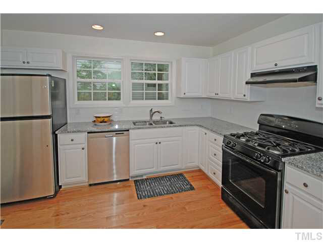1072 Mills Street Raleigh, NC 27608 - Photo 12 of 25 a kitchen with a stove a refrigerator and a sink