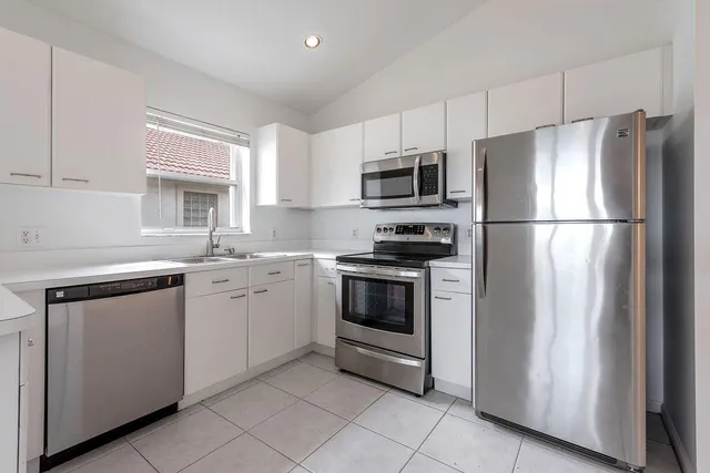a kitchen with cabinets stainless steel appliances and window