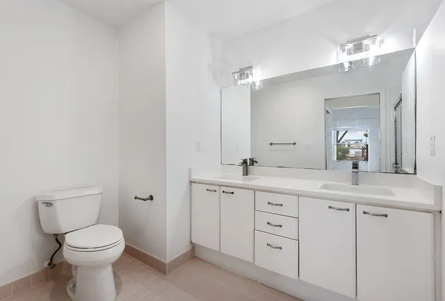 a bathroom with a toilet a sink and mirror