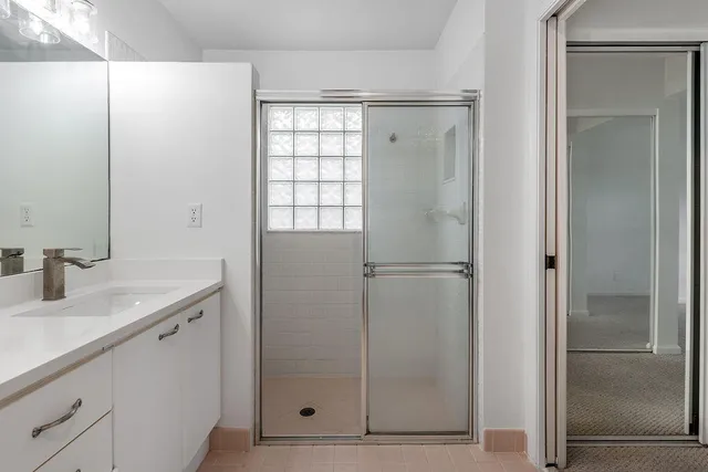 a bathroom with a shower sink and mirror
