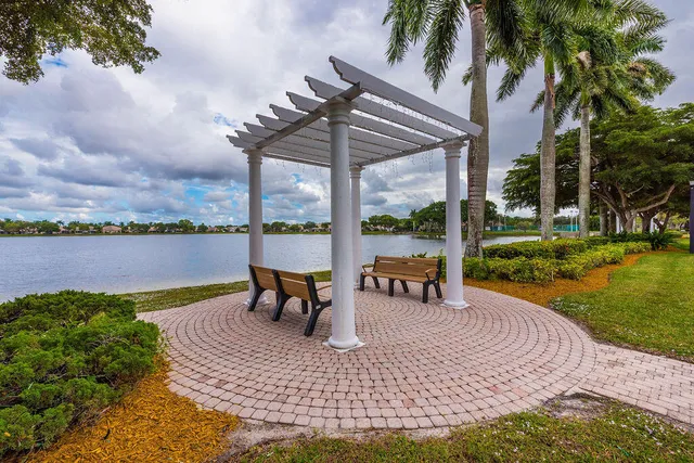 a view of a lake with table and chairs floor to ceiling window and yard