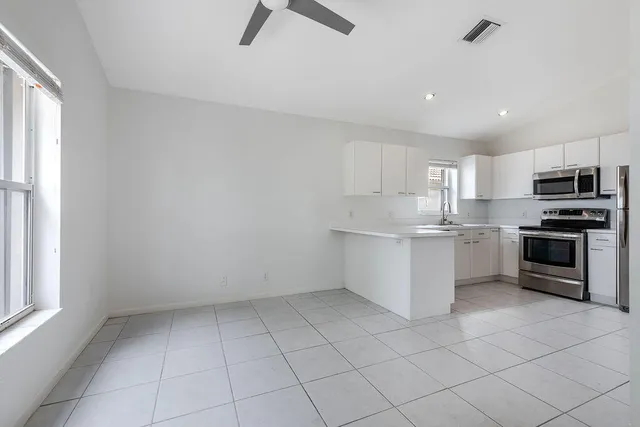 a kitchen with stainless steel appliances a sink a stove a microwave and cabinets