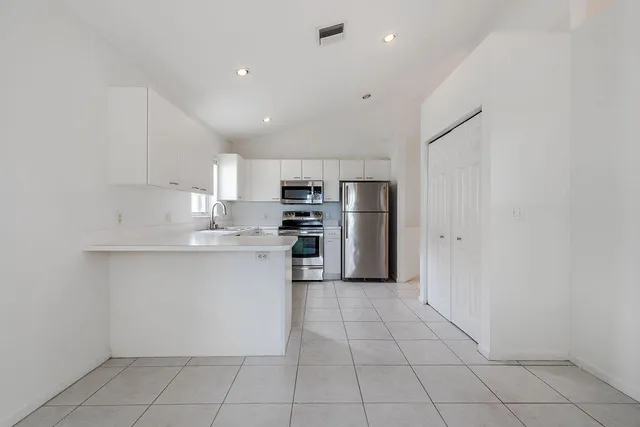 a kitchen with stainless steel appliances a refrigerator sink and microwave