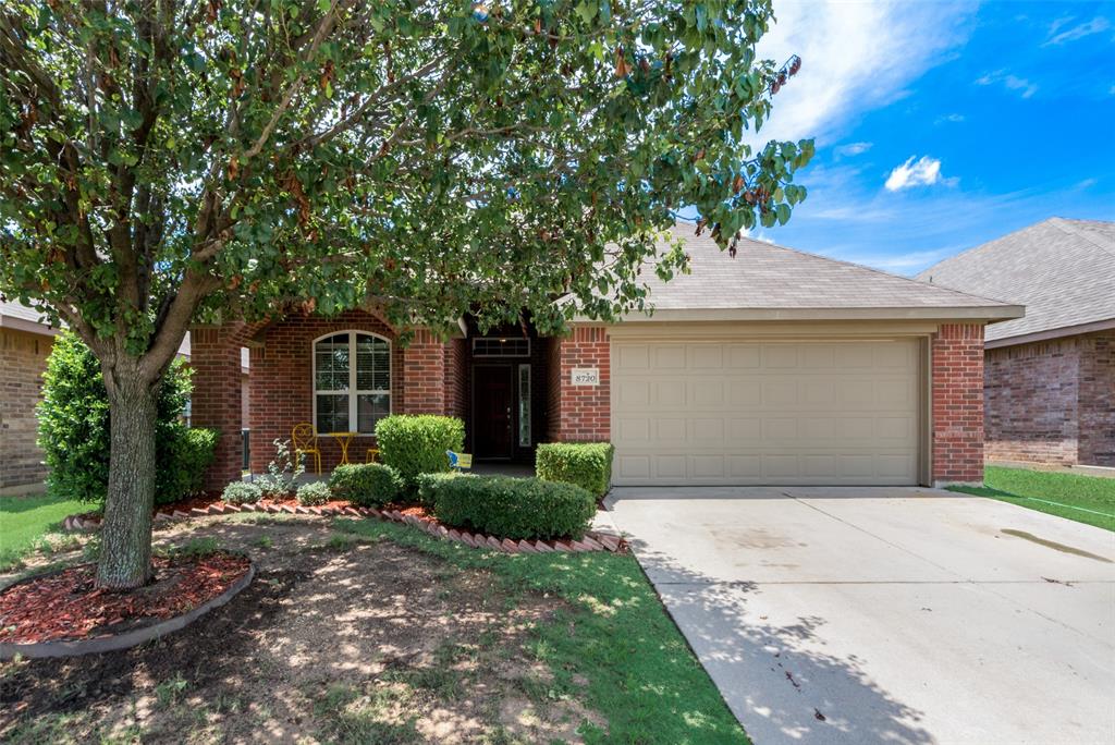 a front view of a house with a garden and trees