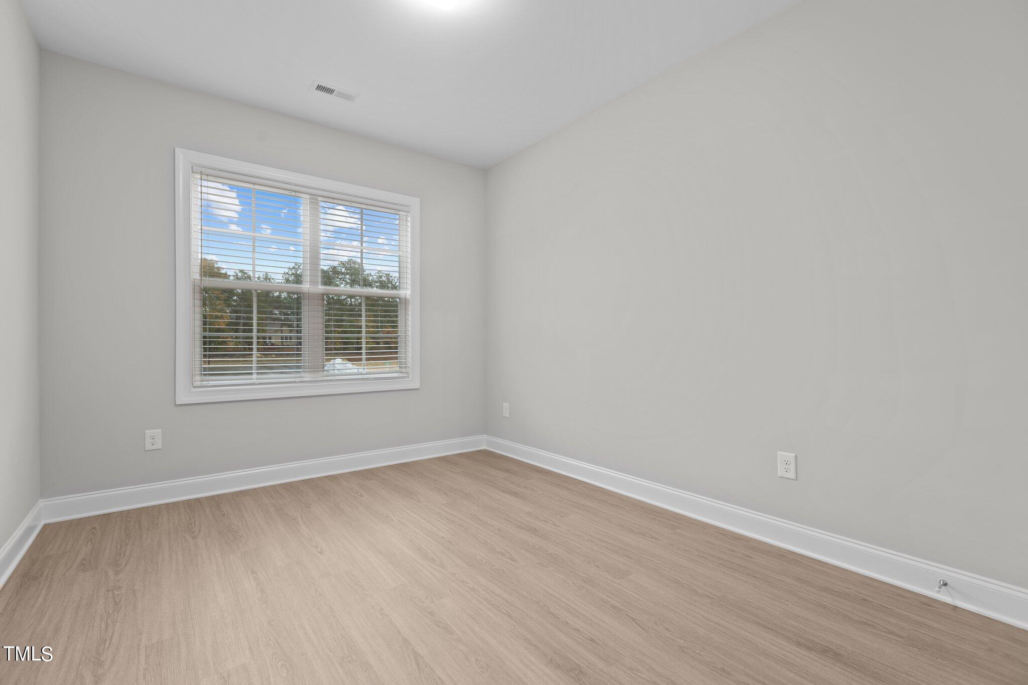 603 Marshskip Way Rolesville, NC 27571 - Photo 22 of 30 a view of an empty room with wooden floor and a window
