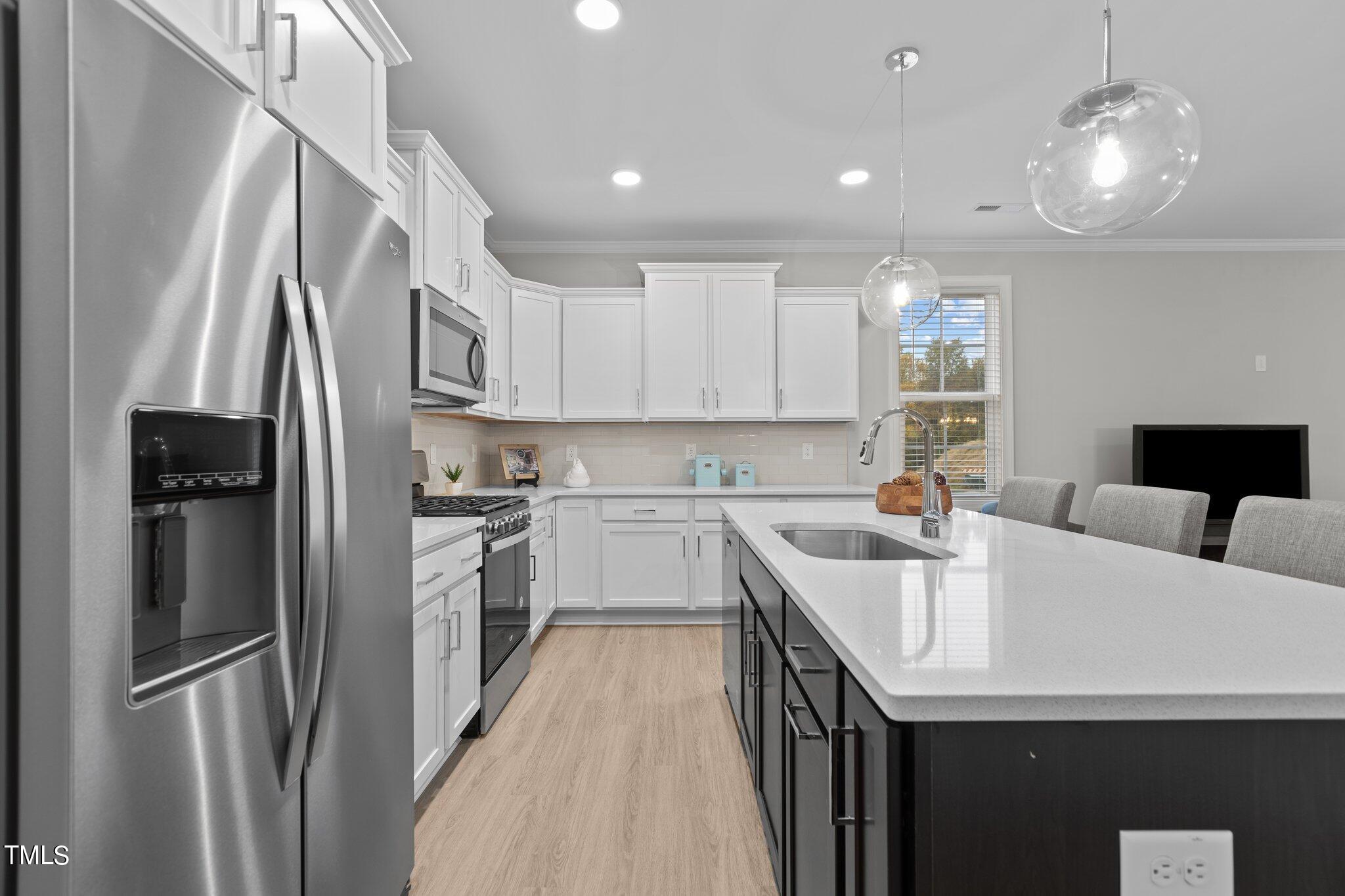 603 Marshskip Way Rolesville, NC 27571 - Photo 5 of 30 a kitchen with stainless steel appliances granite countertop a refrigerator a sink dishwasher a stove and white countertops with wooden floor
