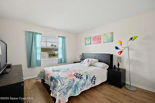 a bedroom with a bed and wooden floor