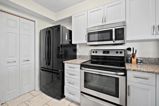 a kitchen with stainless steel appliances white cabinets a stove and a microwave