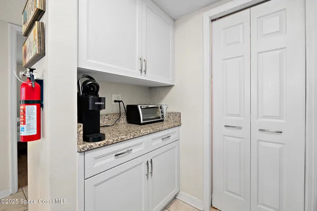 a kitchen with white cabinets and sink