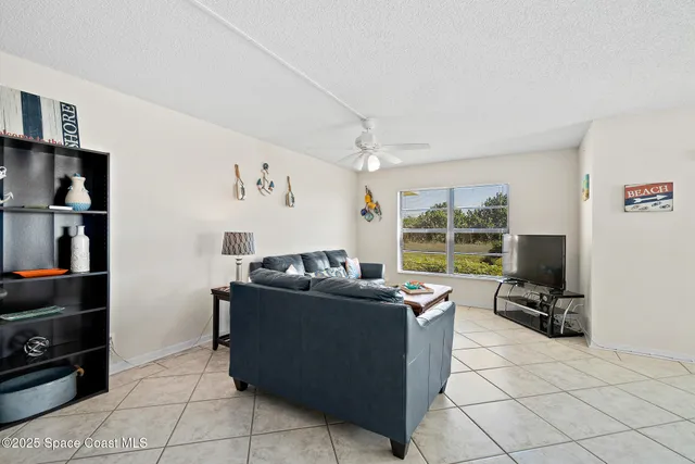 a living room with furniture a flat screen tv and a window