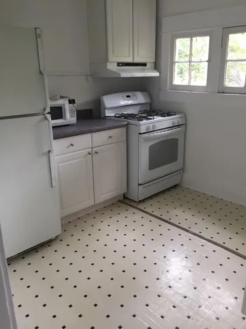 a kitchen with a sink a stove a microwave and cabinets