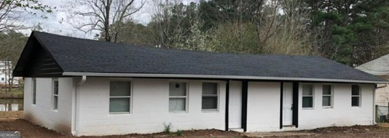 a brick house with large windows and large tree