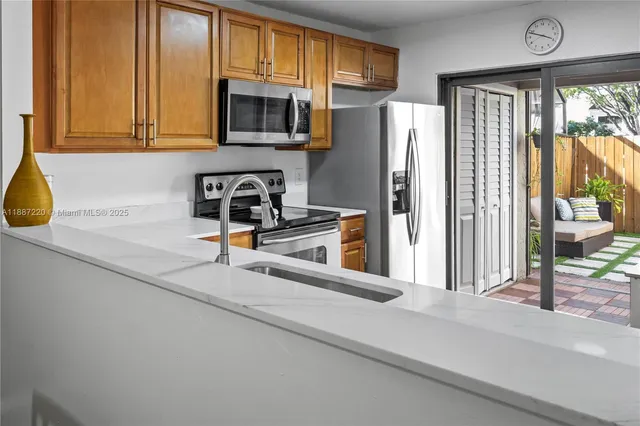 a kitchen with a refrigerator a stove a sink and a window