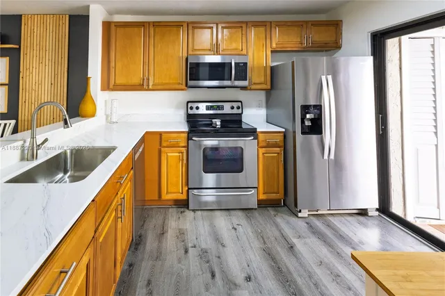 a kitchen with a sink a refrigerator and a stove top oven