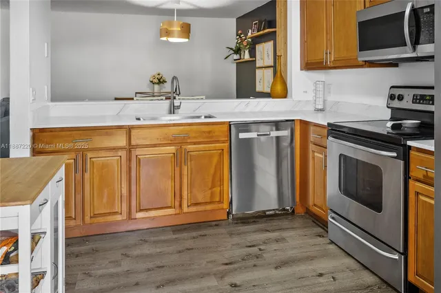 a kitchen with stainless steel appliances granite countertop a sink stove and microwave