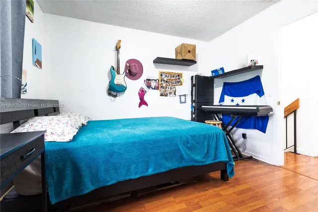 a bedroom with a bed and wooden floor