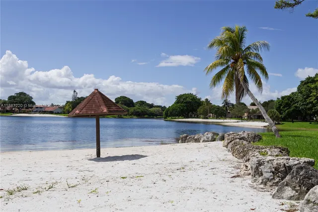 a view of a terrace with a table and chairs under an umbrella