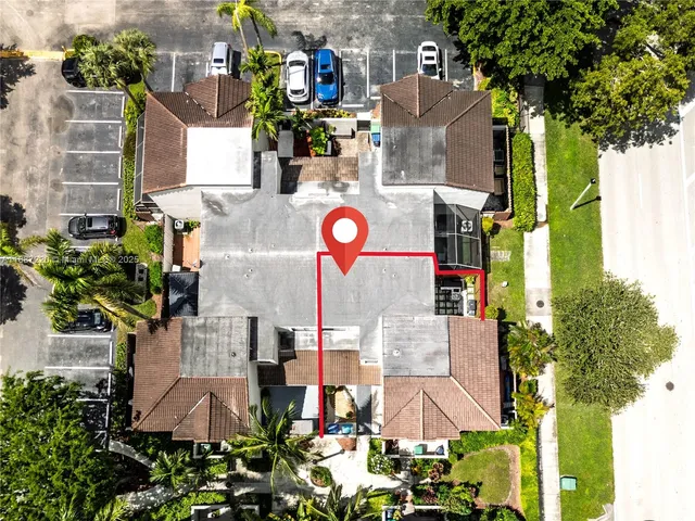 an aerial view of residential houses with outdoor space and parking