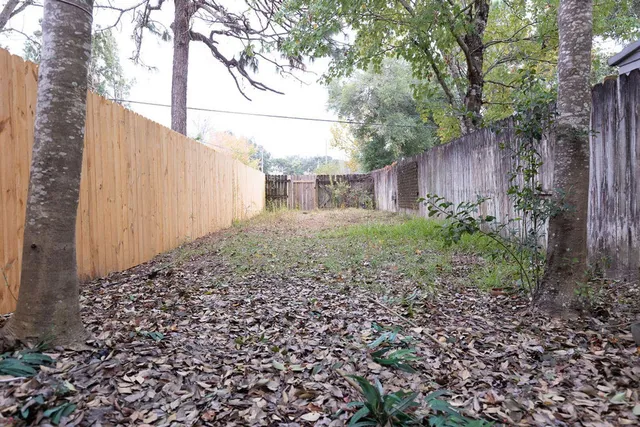 a view of a brick house with wooden fence